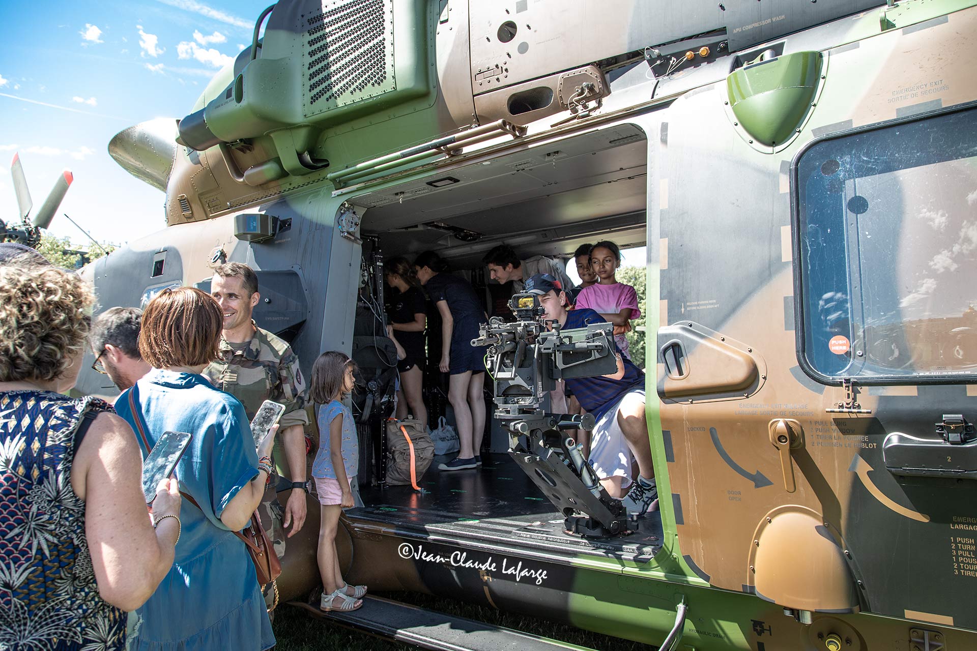Le public visite les matériels à l'intérieur d'un hélicoptère militaire.